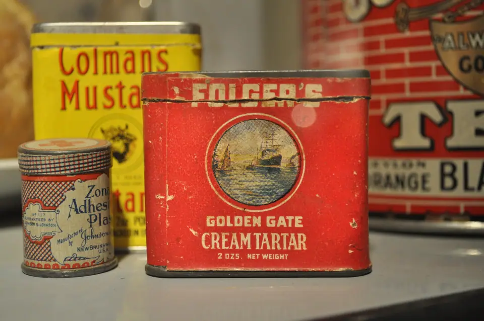 Latas antiguas de cremor tártaro y mostaza en una alacena