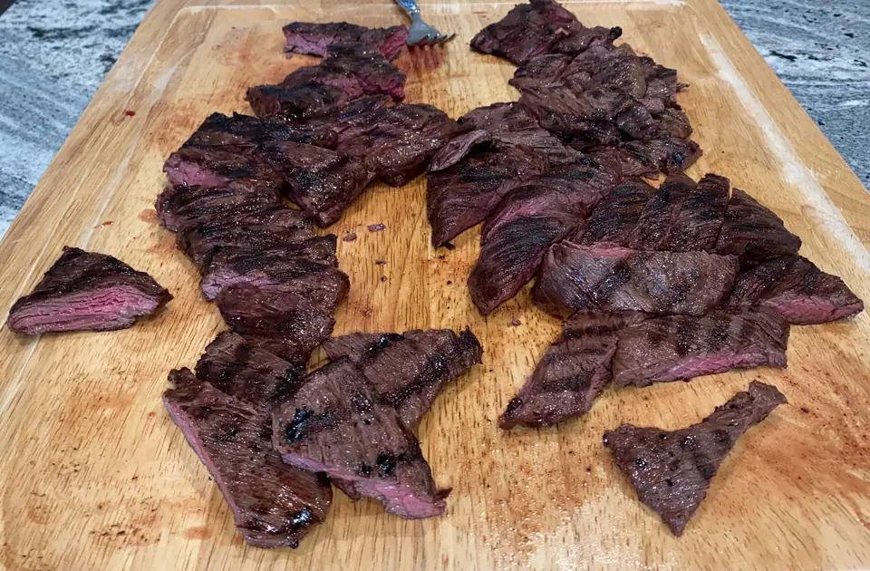 Entraña a la parrilla cortada en trozos sobre una tabla de madera