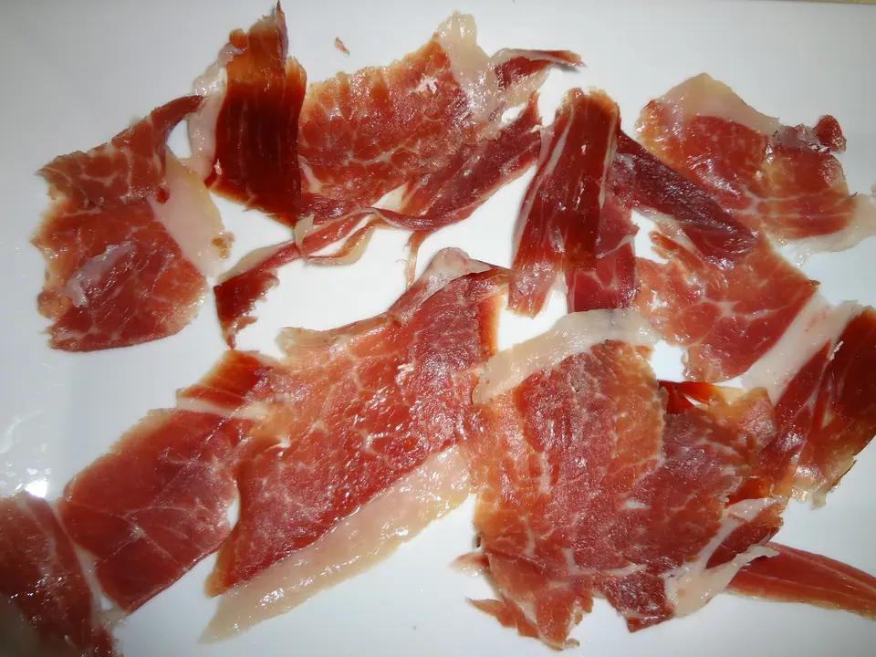 Fetas de jamón crudo (serrano) sobre un plato blanco