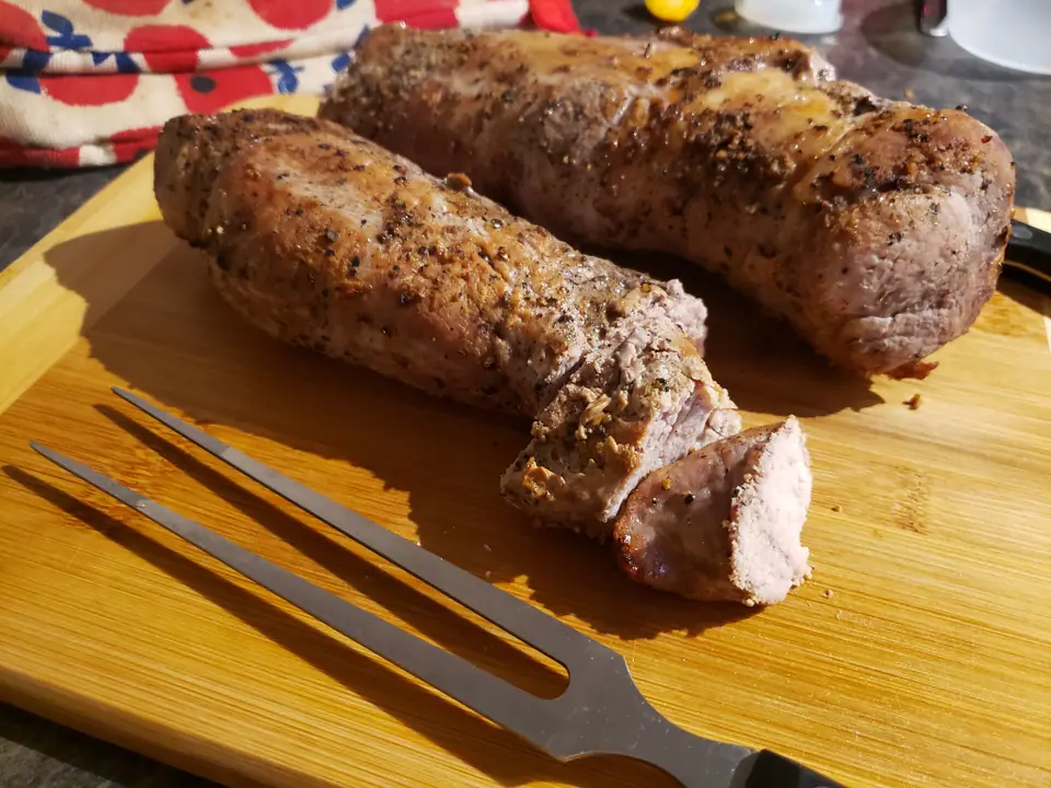 Dos solomillos de cerdo asados sobre una tabla, uno cortado en la punta