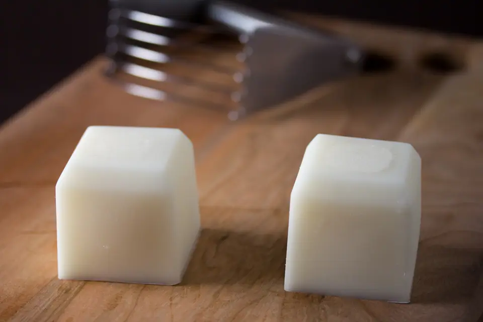Dos cubos blancos de grasa vegetal sólida sobre una tabla de madera