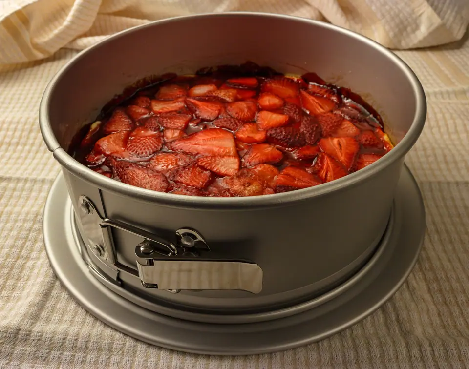 Torta con frutillas dentro de un molde redondo desmontable
