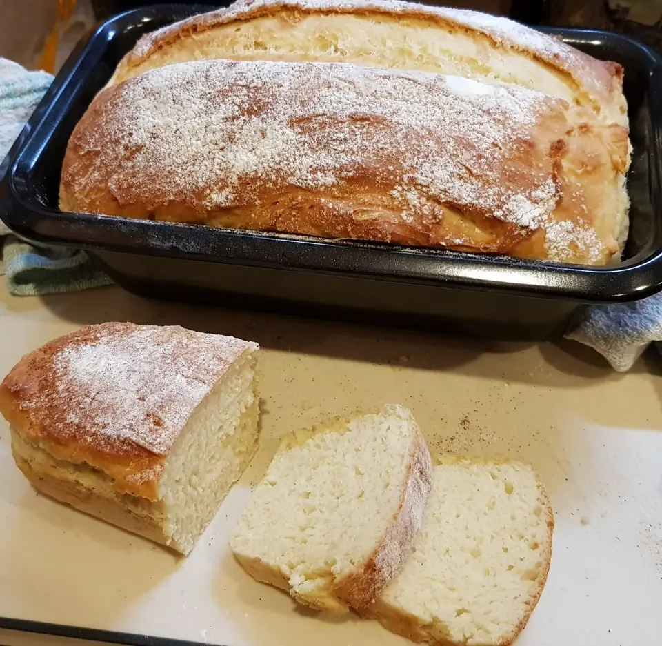 Pan de molde casero en su molde y otro cortado en rodajas