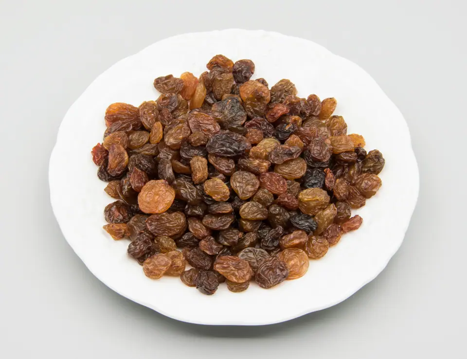 Plato blanco con uvas pasas rubias y negras