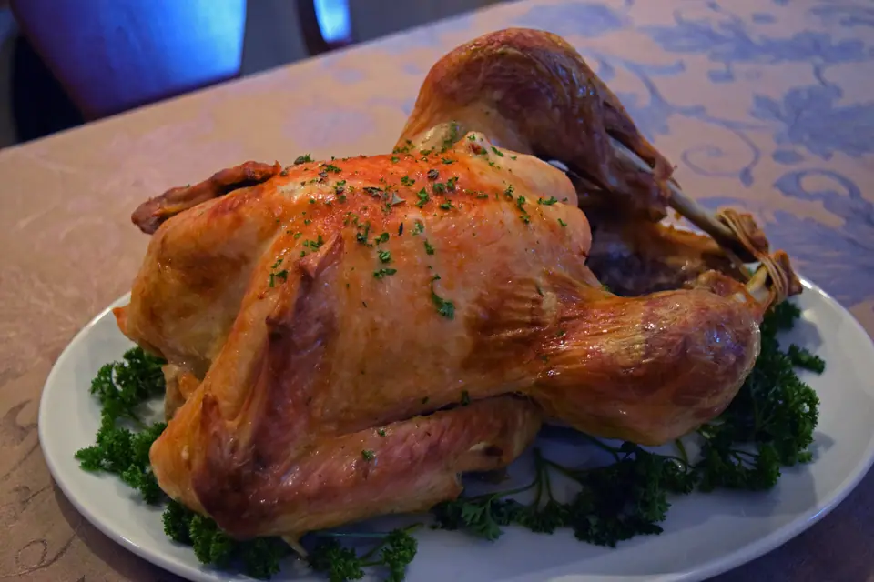 Pavo entero asado y dorado en una fuente con perejil